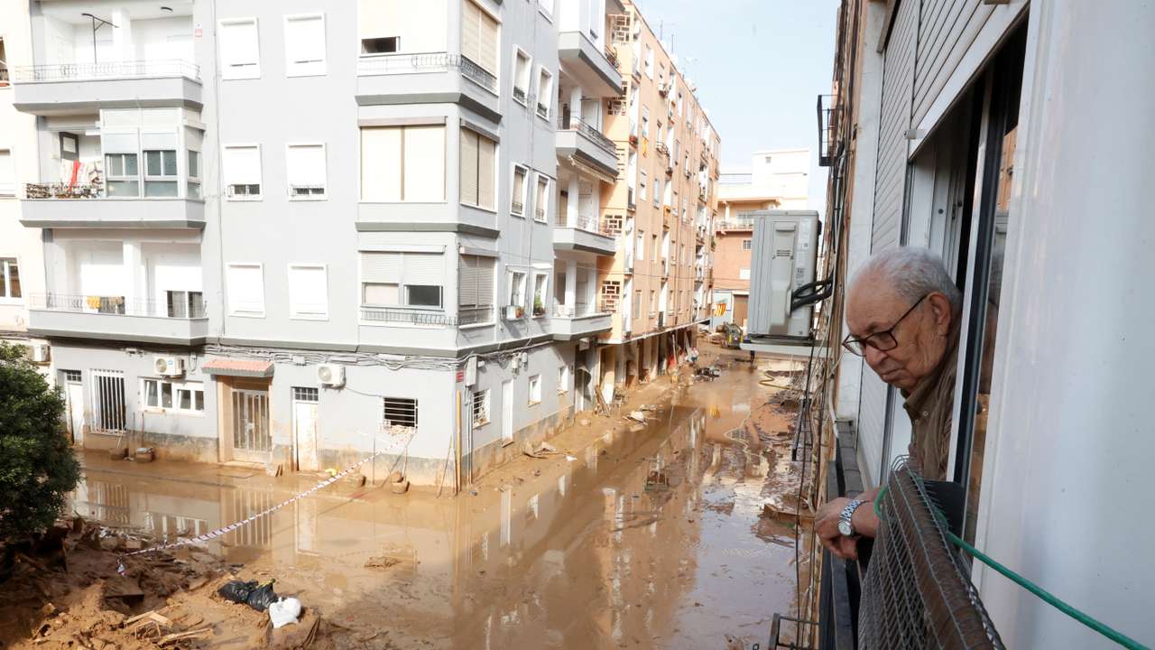 Cristobal Martinez, 87, looks out of his window at the muddy streets in Paiporta