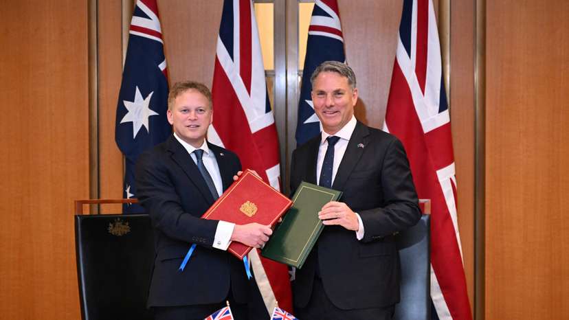 Secretary of State for Defence of the UK Shapps and Australian Defence Minister Marles exchange Defence Treaty documents during a meeting in Canberra