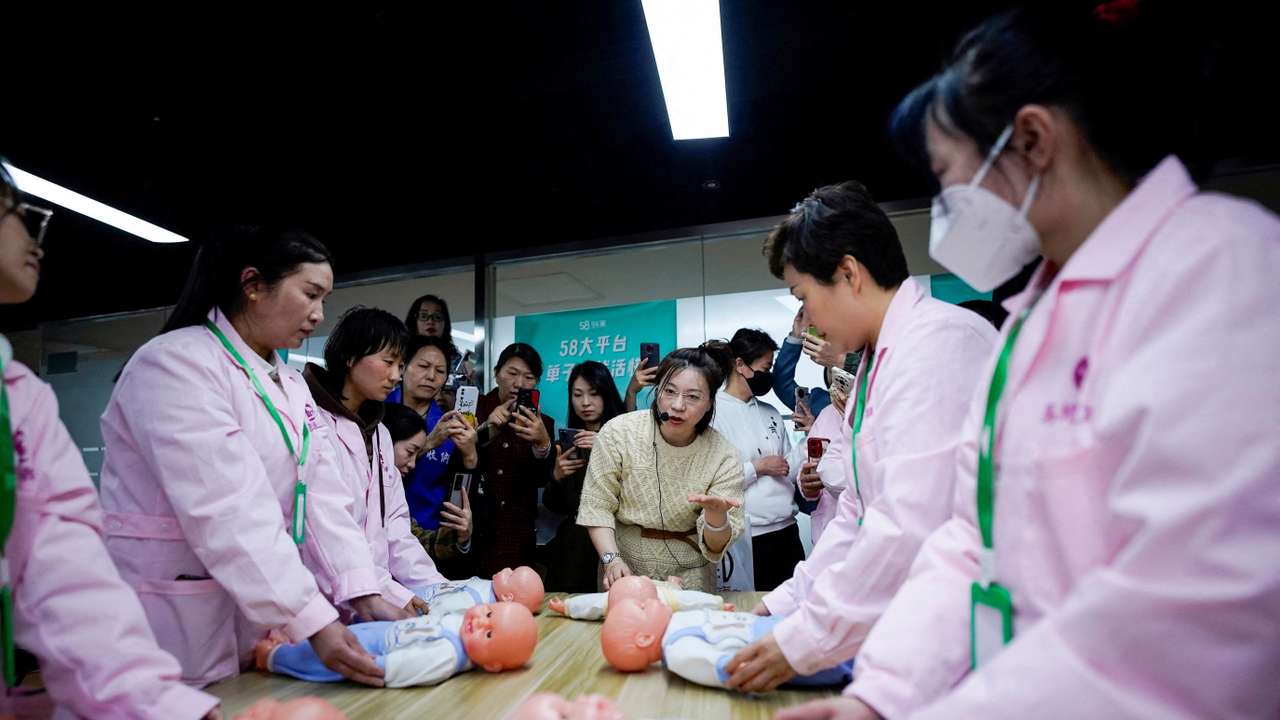 FILE PHOTO: Women take part in a nursing skills class for confinement carers, in Shanghai