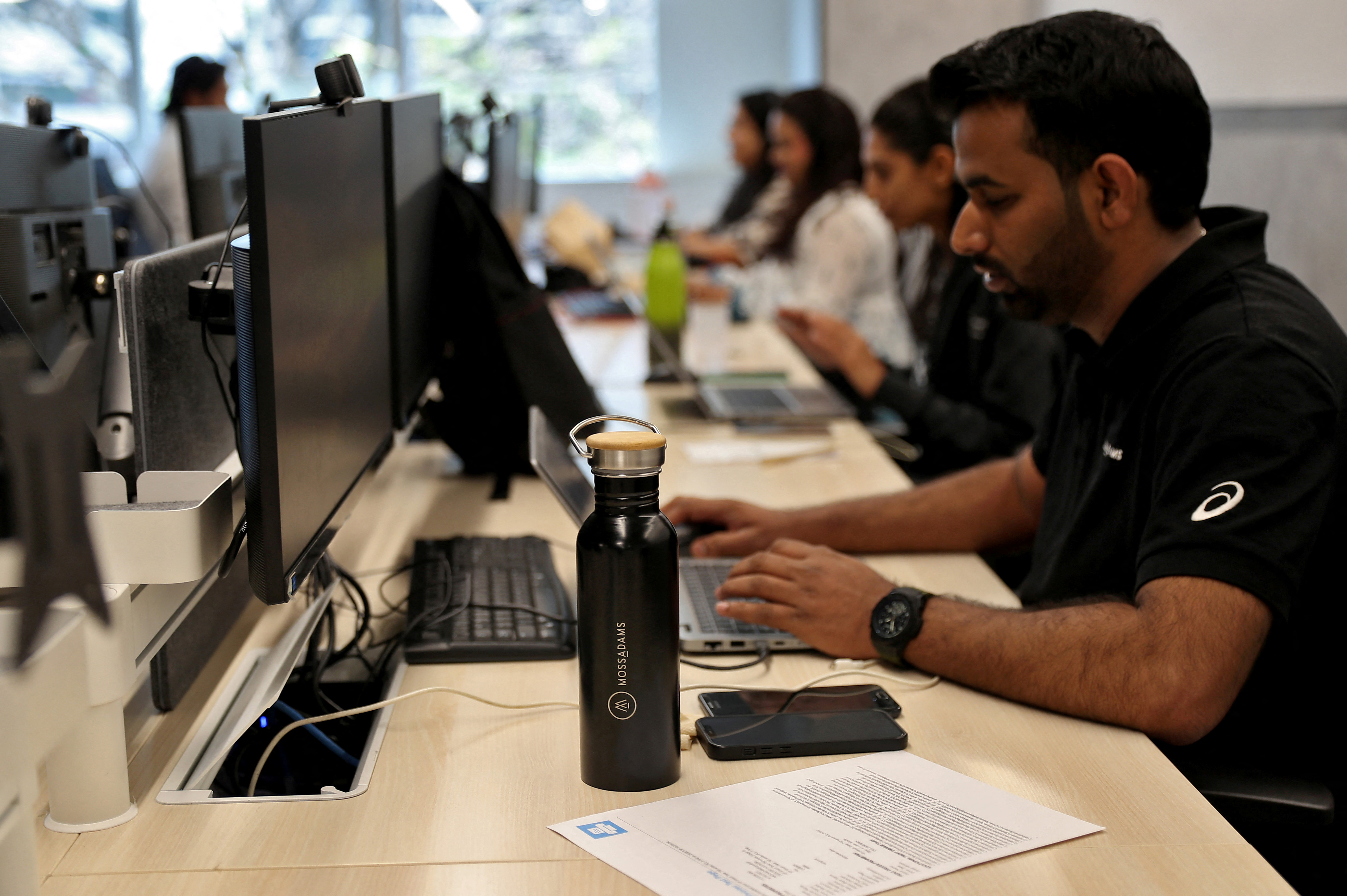 Employees work inside the office of Moss Adams, a U.S. accounting firm, in Bengaluru