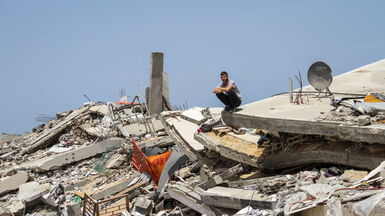 FILE PHOTO: A Palestinian man sits on the rubble of a house destroyed by Israeli strikes, amid the ongoing conflict between Israel and Hamas, in the northern Gaza Strip