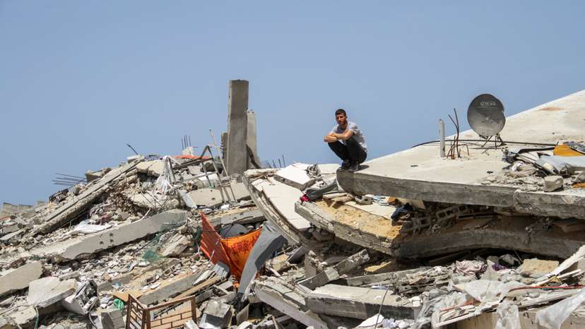 FILE PHOTO: A Palestinian man sits on the rubble of a house destroyed by Israeli strikes, amid the ongoing conflict between Israel and Hamas, in the northern Gaza Strip