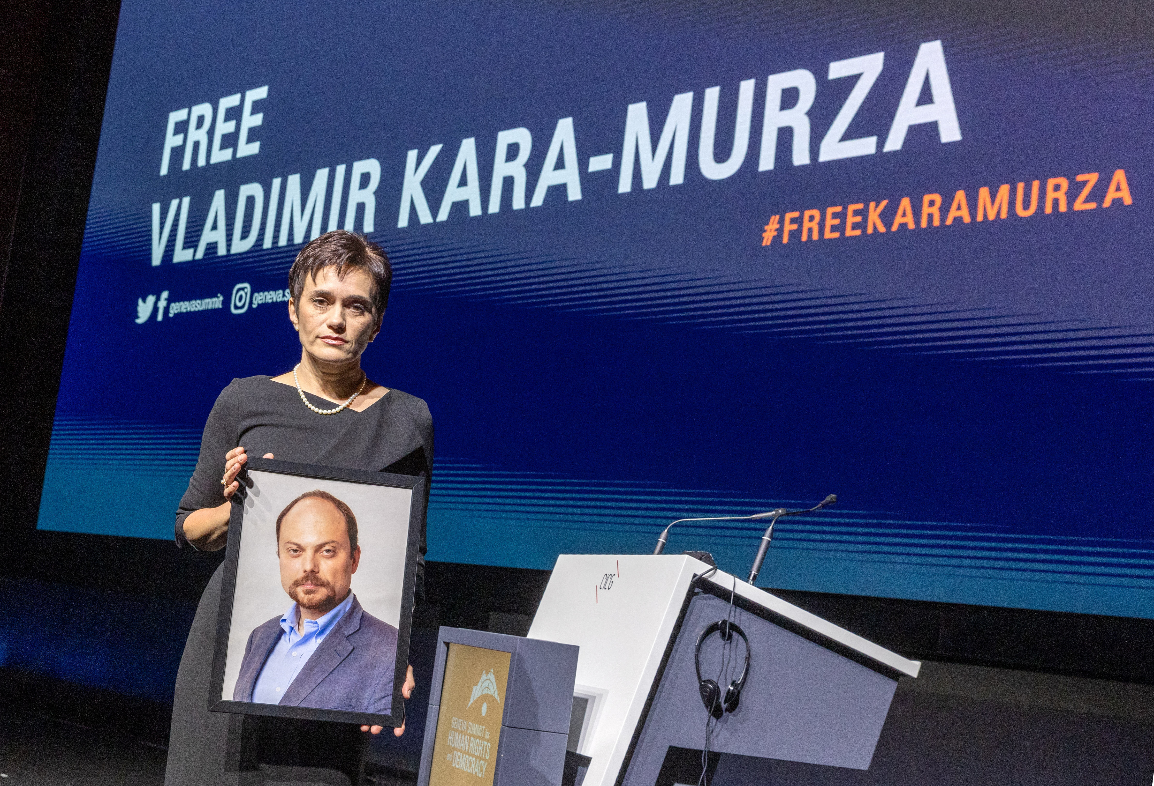 Evgenia wife of jailed Russian opposition figure Kara-Murza poses with a picture of her husband in Geneva
