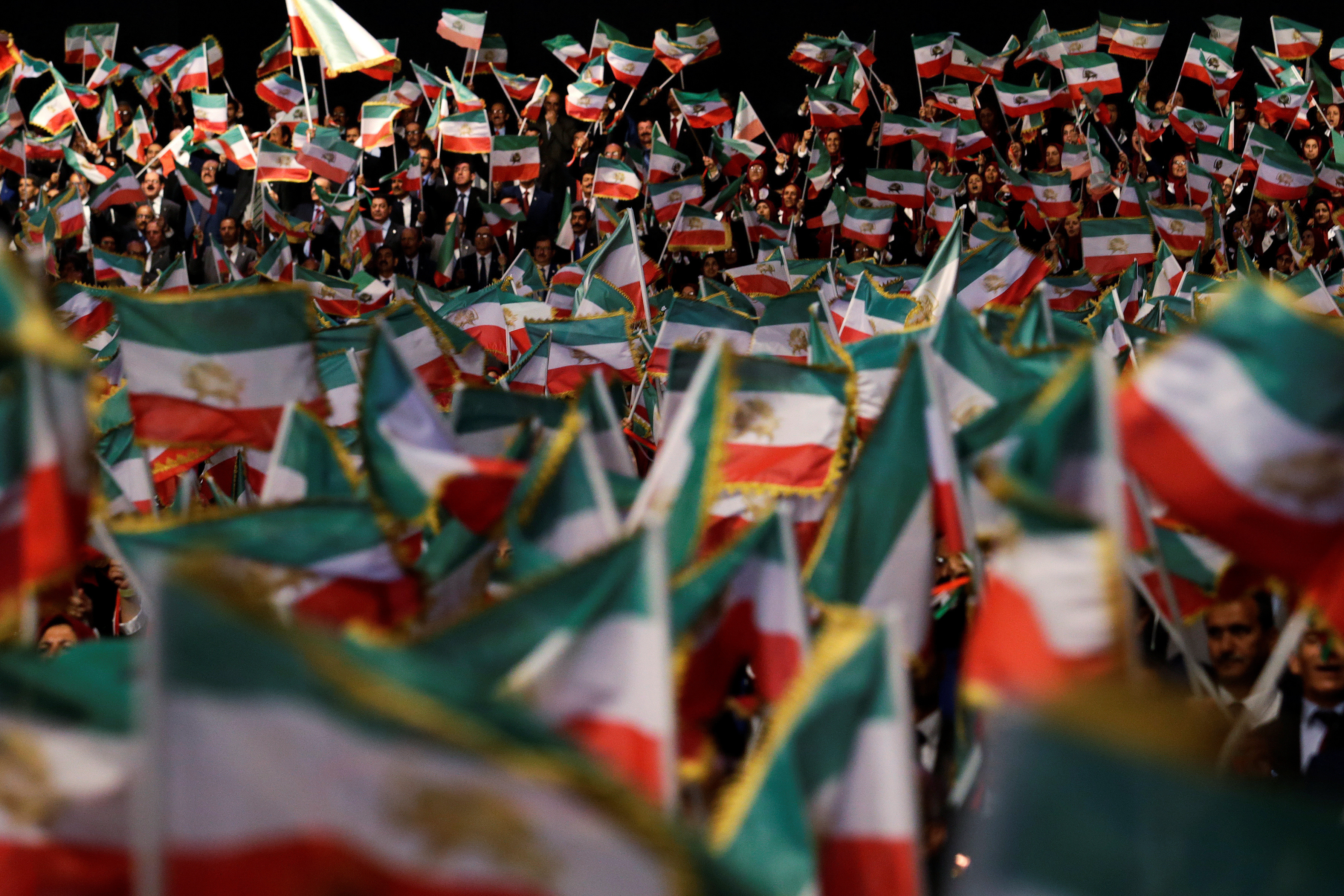 People wave flags during at an event in Ashraf-3 camp, which is a base for the People's Mojahedin Organization of Iran (MEK) in Manza
