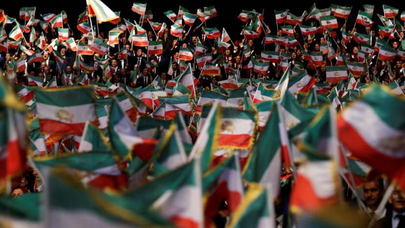 People wave flags during at an event in Ashraf-3 camp, which is a base for the People's Mojahedin Organization of Iran (MEK) in Manza
