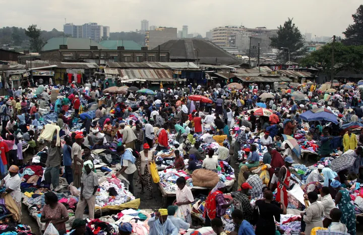 Sellers offering second-hand clothes wait for customers in a market in Uganda