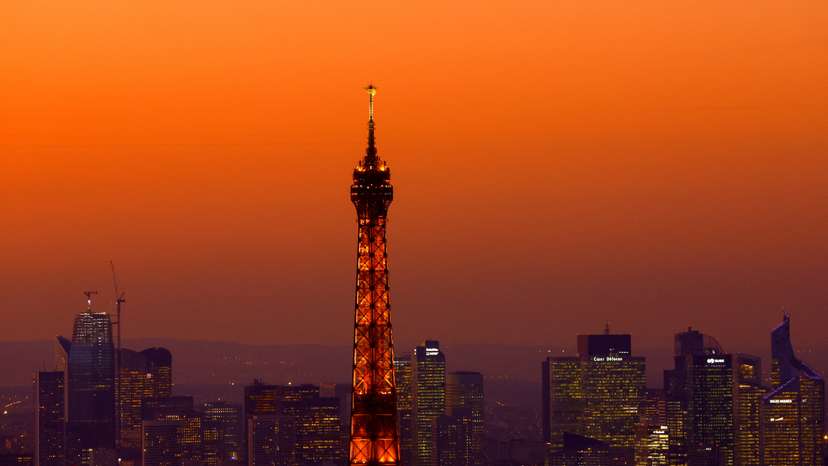 A view at sunset shows the Eiffel Tower and the financial and business district of La Defense in Puteaux near Paris
