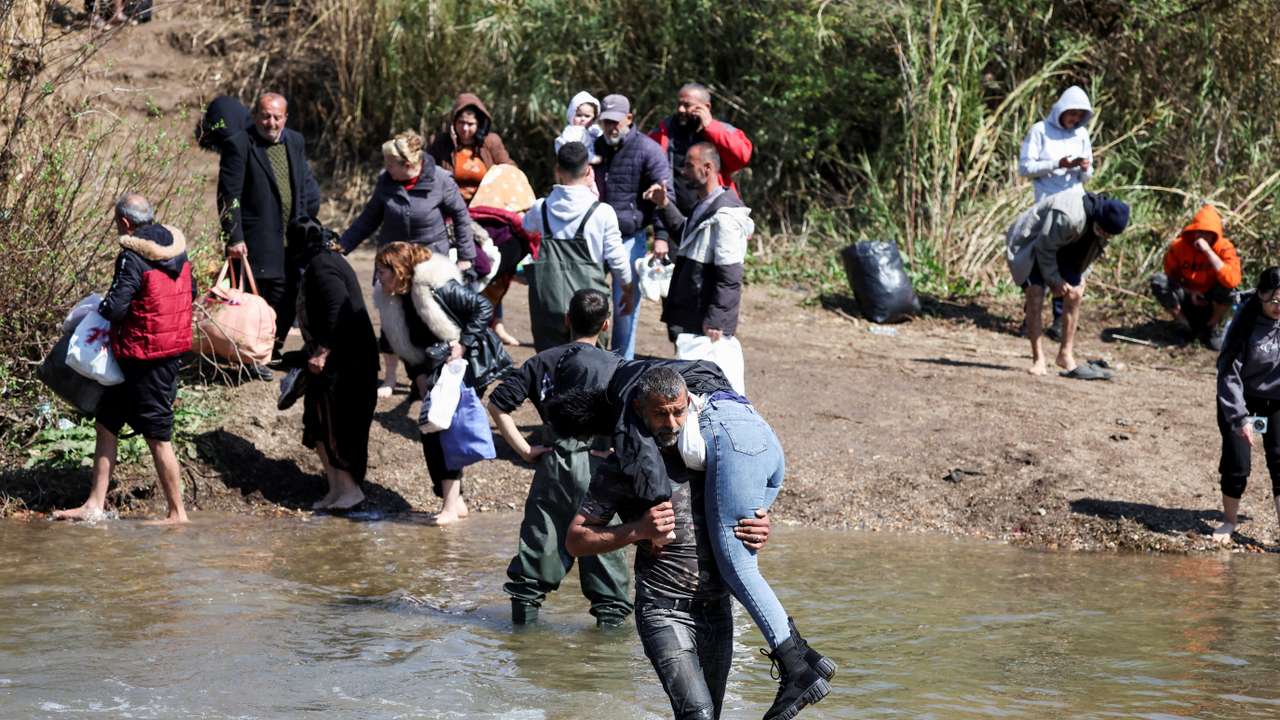 Alawite Syrians, who fled the violence in western Syria, walk at the water of Nahr El Kabir, in Akkar