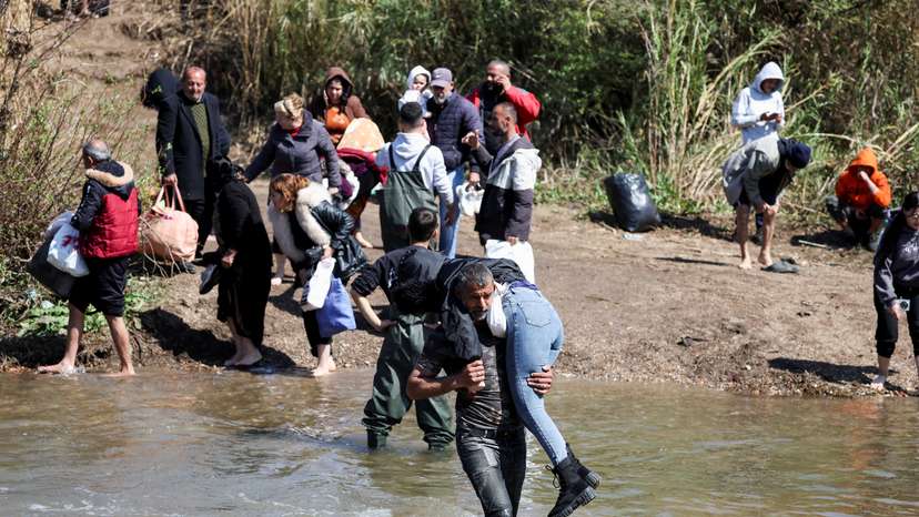 Alawite Syrians, who fled the violence in western Syria, walk at the water of Nahr El Kabir, in Akkar
