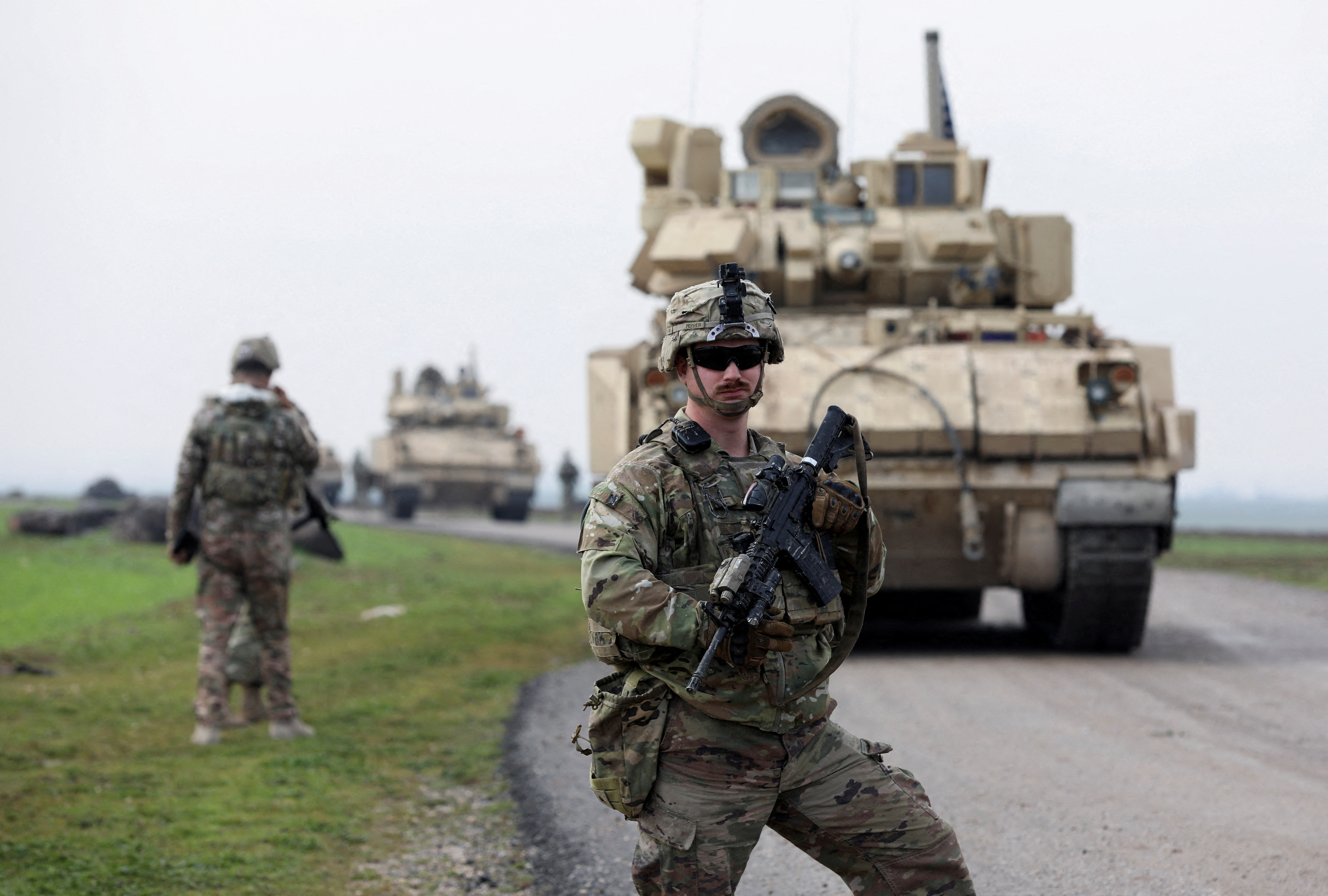 FILE PHOTO: A soldier from the US-led coalition stands guard during a joint U.S.- Kurdish-led Syrian Democratic Forces (SDF) patrol in the countryside of Qamishli