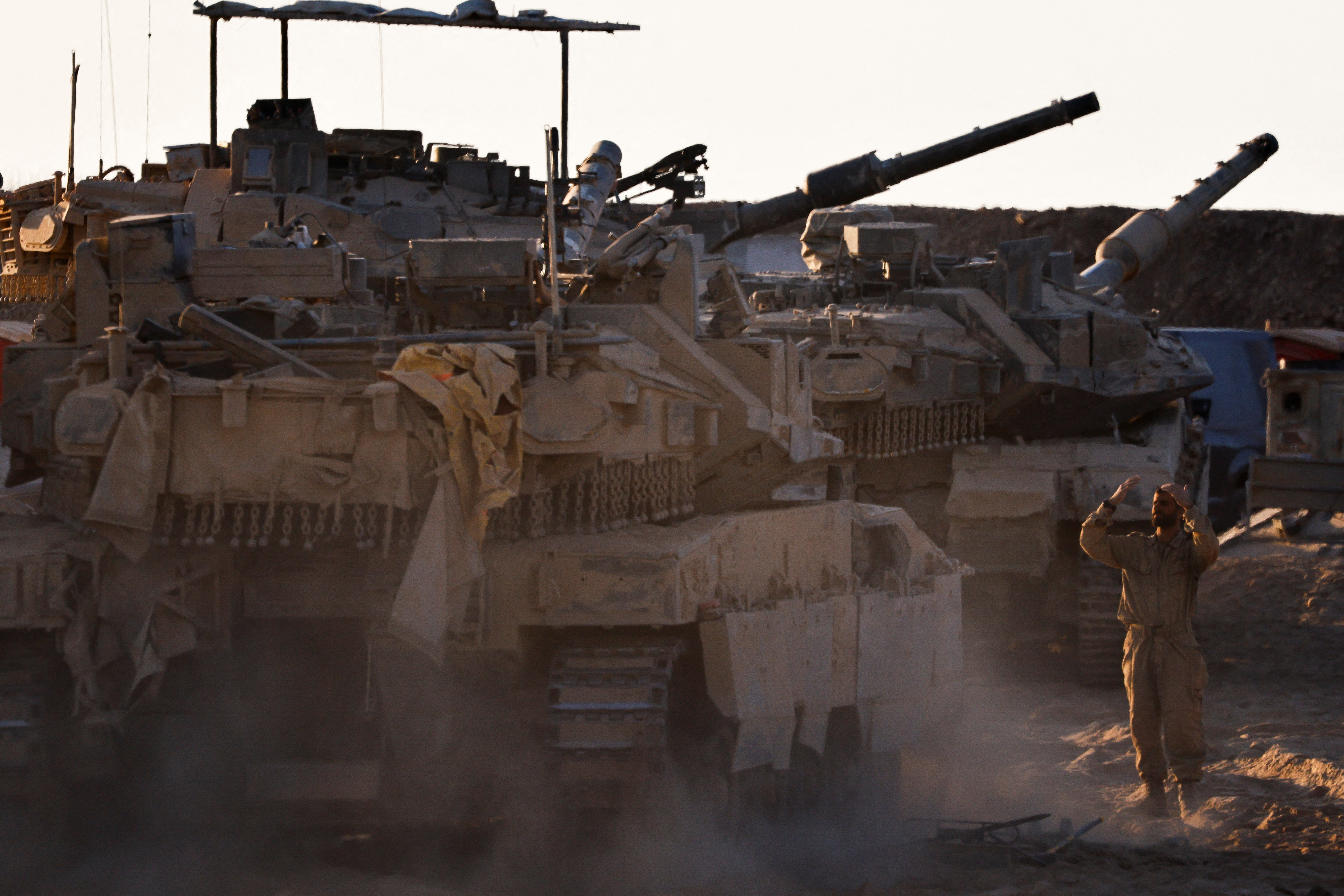 An Israeli soldier directs a tank near the border with Gaza