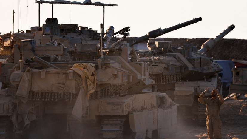 An Israeli soldier directs a tank near the border with Gaza