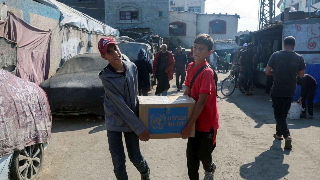Palestinians receive aid from UNRWA in Deir Al-Balah, central Gaza Strip