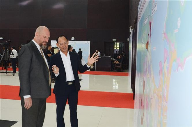 A Vietnamese business representative talks to a foreign partner about the Da Nang FTZ at the ceremony