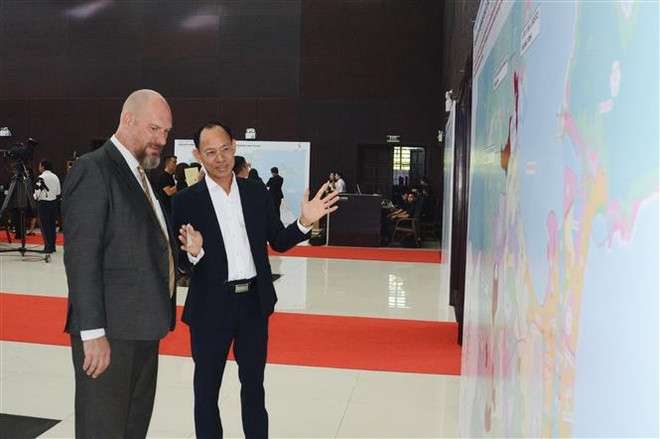 A Vietnamese business representative talks to a foreign partner about the Da Nang FTZ at the ceremony