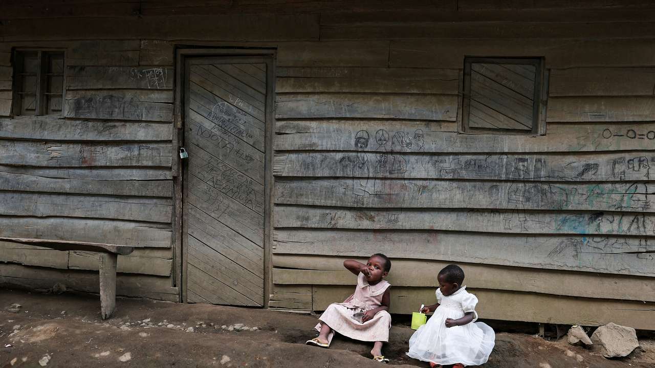 FILE PHOTO: Girls eat outside their parent's house in Mushaki