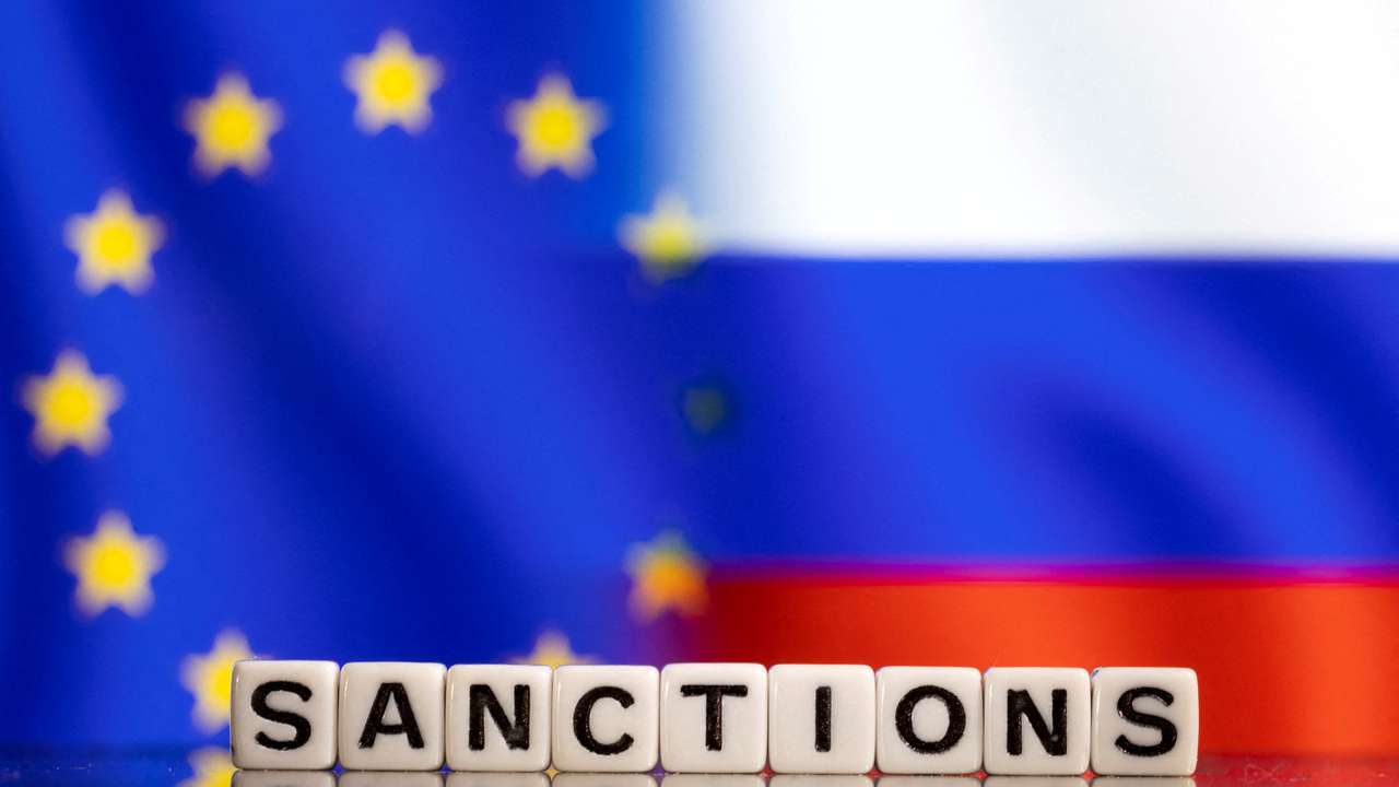 Illustration shows letters arranged to read "Sanctions" in front of EU and Russia's flag colors