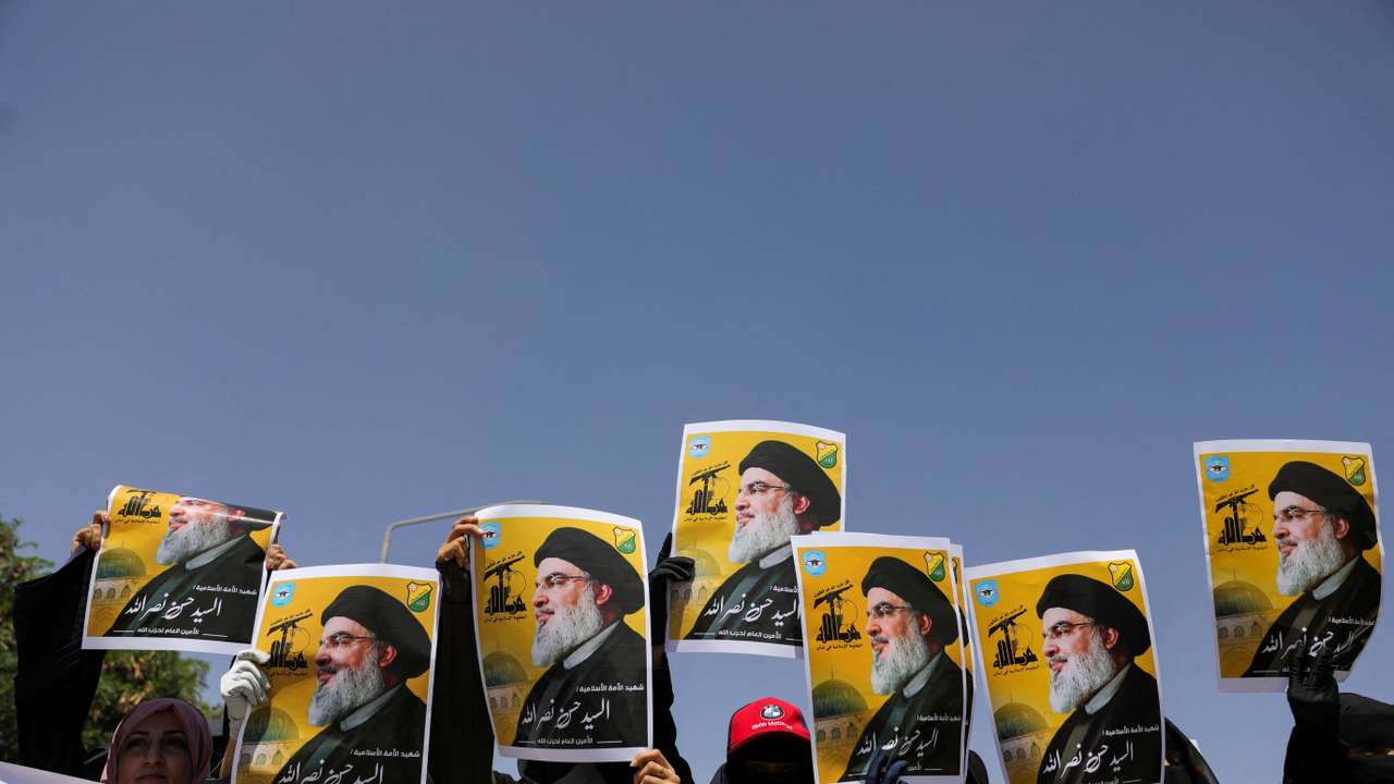 Students hold posters of Hassan Nasrallah, the assassinated chief of Lebanon's Hezbollah, during a rally in Sanaa