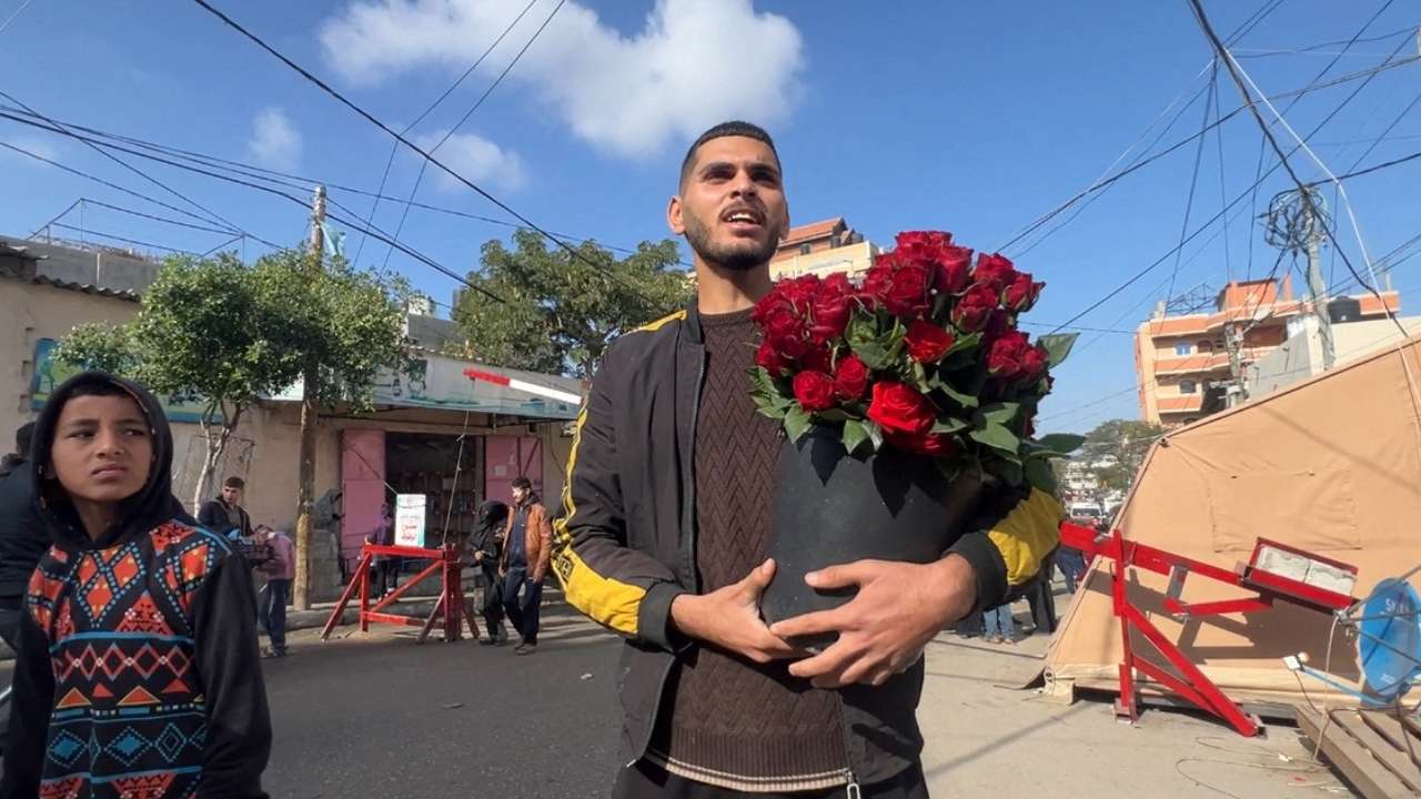 Hussam Abdulhadi, a displaced Palestinian florist, sells flowers, in Rafah