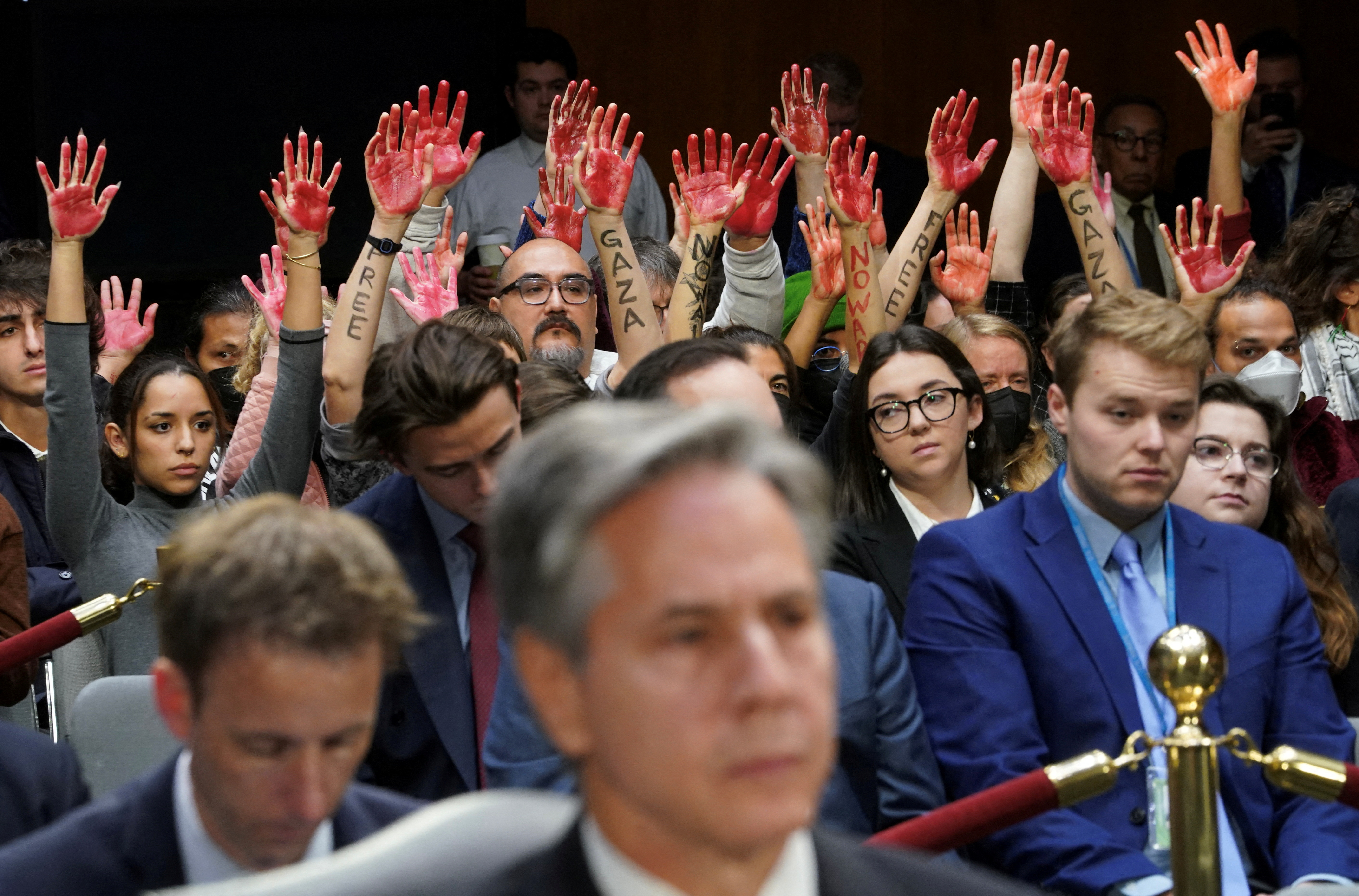 Anti-war protesters raise "bloody" hands behind Blinken at hearing on Capitol Hill in Washington