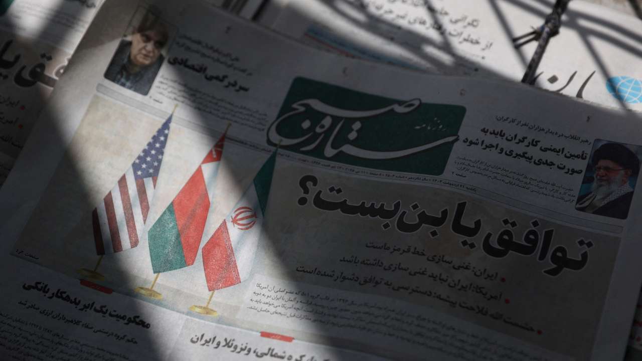 An Iranian newspaper with a cover photo of Iran, Oman and U.S. Flags, is seen in Tehran