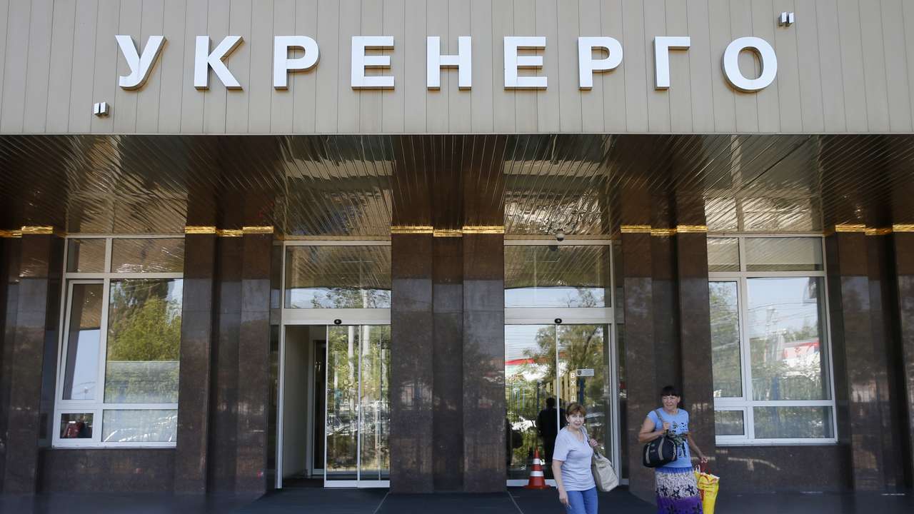 Women walk outside the headquarters of Ukrainian state power distributor Ukrenergo in Kiev