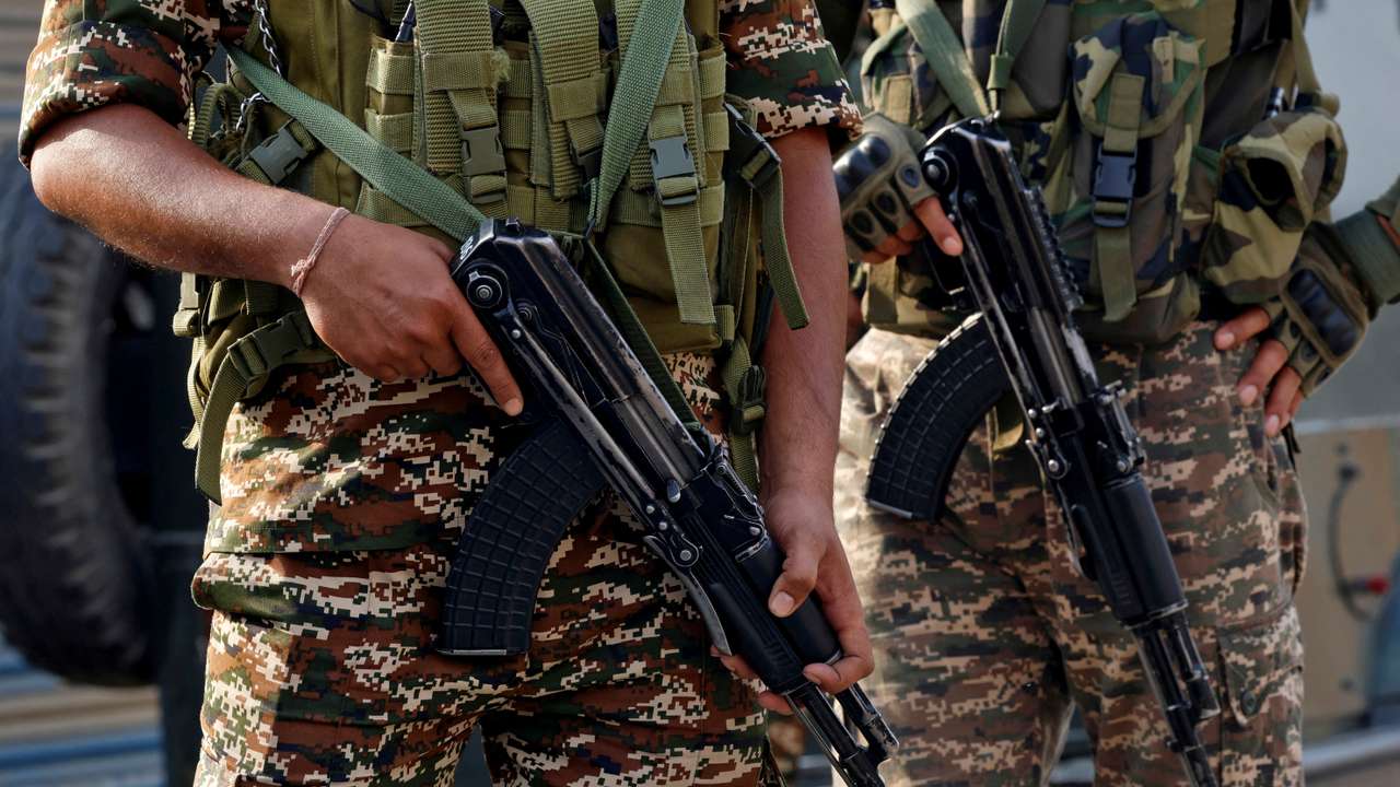 Indian security force personnel stand guard near the site of a fighter jet crash in Wuyan