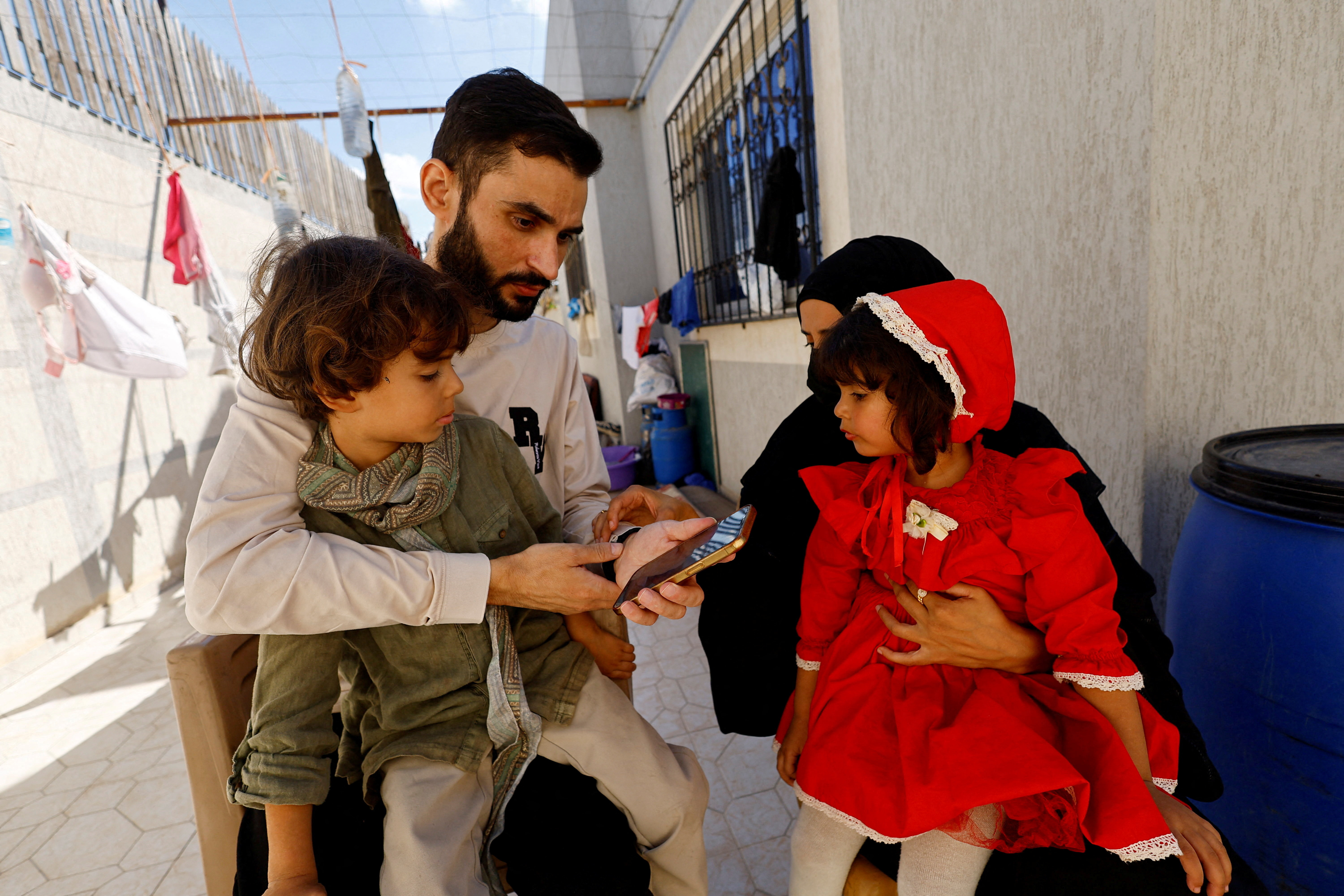 Freed Palestinian detainee Shadi Abu Sido sits with his wife Hanaa Bahlul and their children at their home in Nuseirat
