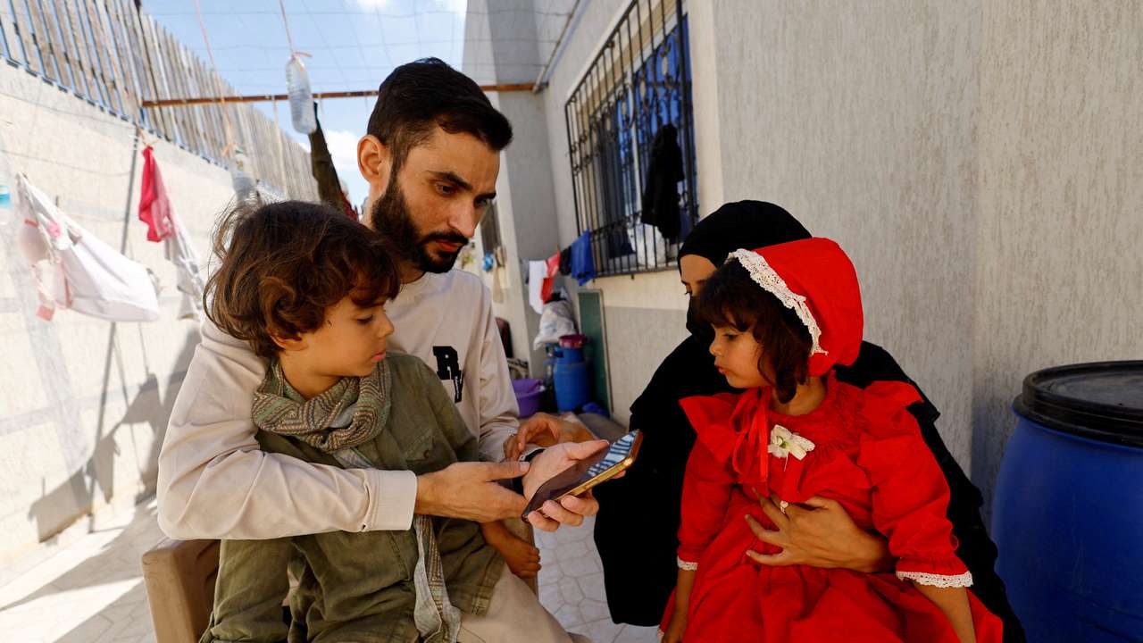 Freed Palestinian detainee Shadi Abu Sido sits with his wife Hanaa Bahlul and their children at their home in Nuseirat