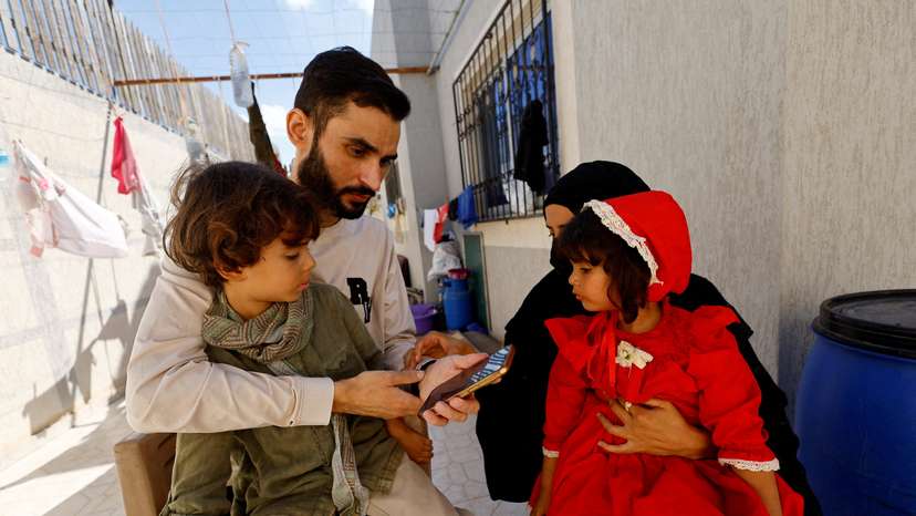 Freed Palestinian detainee Shadi Abu Sido sits with his wife Hanaa Bahlul and their children at their home in Nuseirat