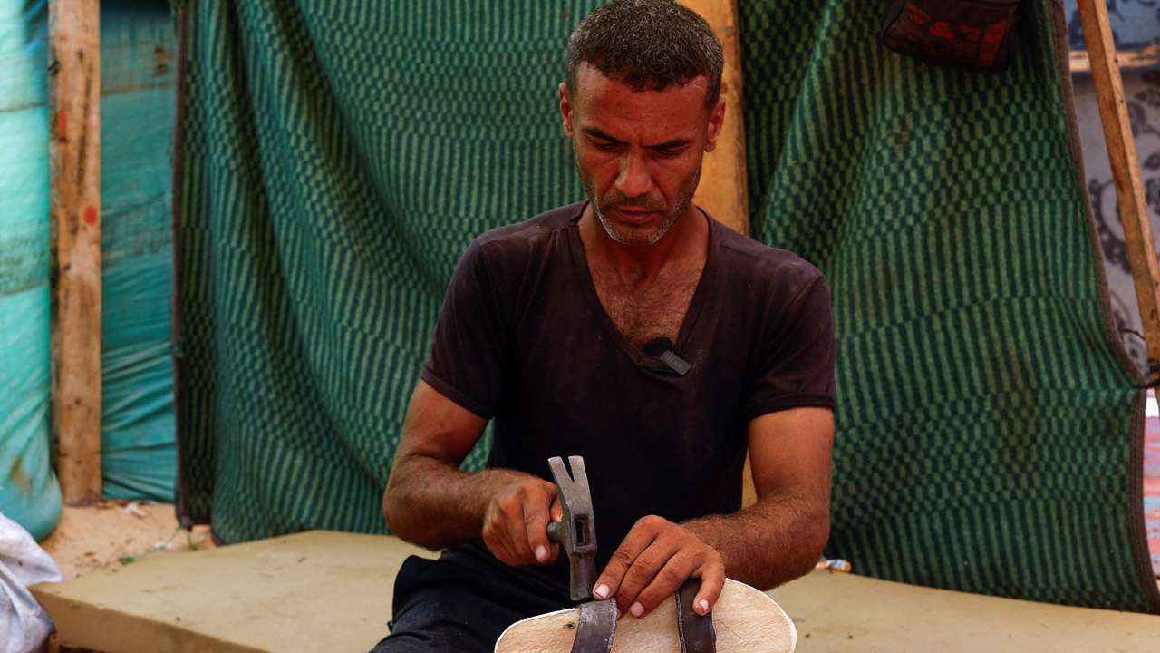 Carpenter carves out wooden footwear for children in Gaza