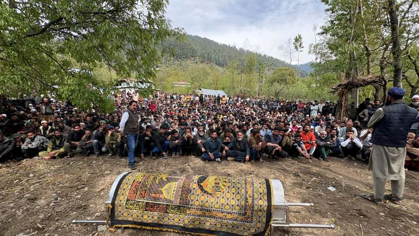 FILE PHOTO: Kashmiri villagers sit next to the coffin of Adil Hussain Shah before his funeral prayers at his village in Hapatnar