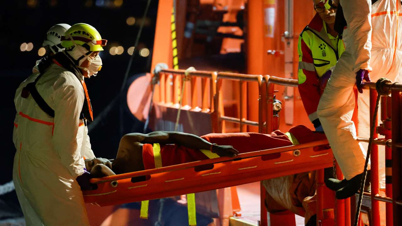 Rescuers disembark a migrant in critical condition from a Spanish coast guard vessel at the port of Arguineguin