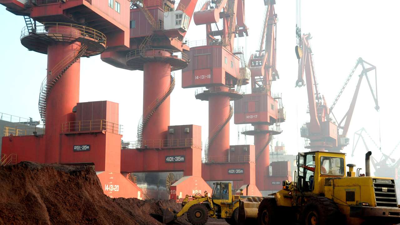 FILE PHOTO: Workers transport soil containing rare earth elements for export at a port in Lianyungang