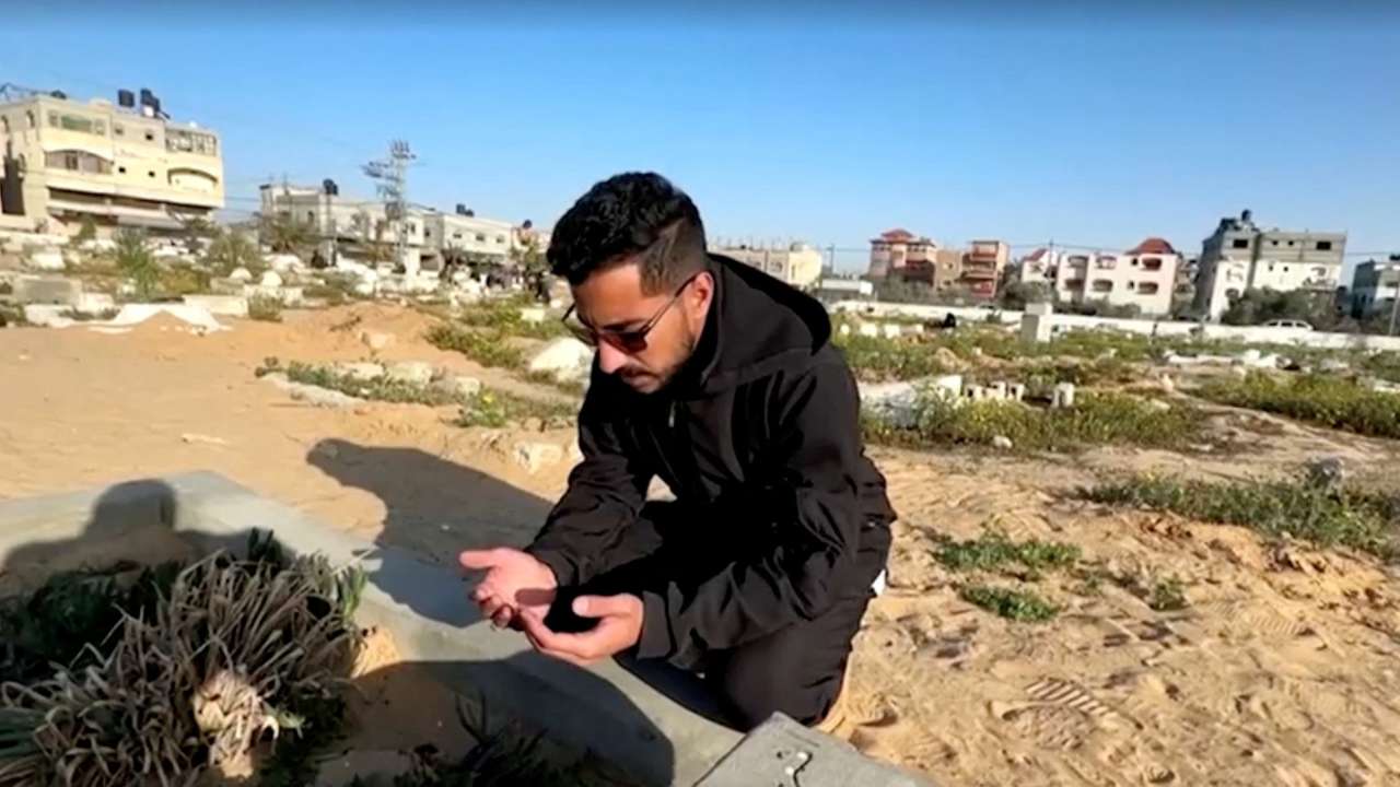 Palestinian man Ibrahim Hassouna, who lost his family during Israel's military offensive, prays at a grave during the holy month of Ramadan, in Rafah, in the southern Gaza Strip
