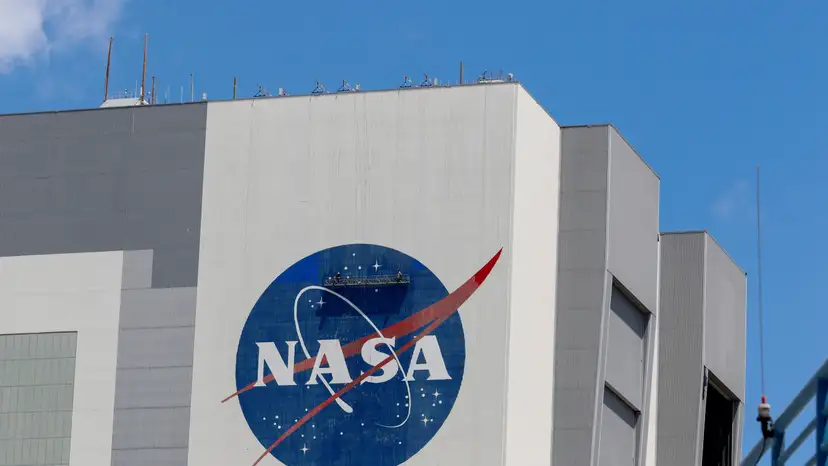 Workers pressure wash the logo of NASA on the Vehicle Assembly Building, in Cape Canaveral