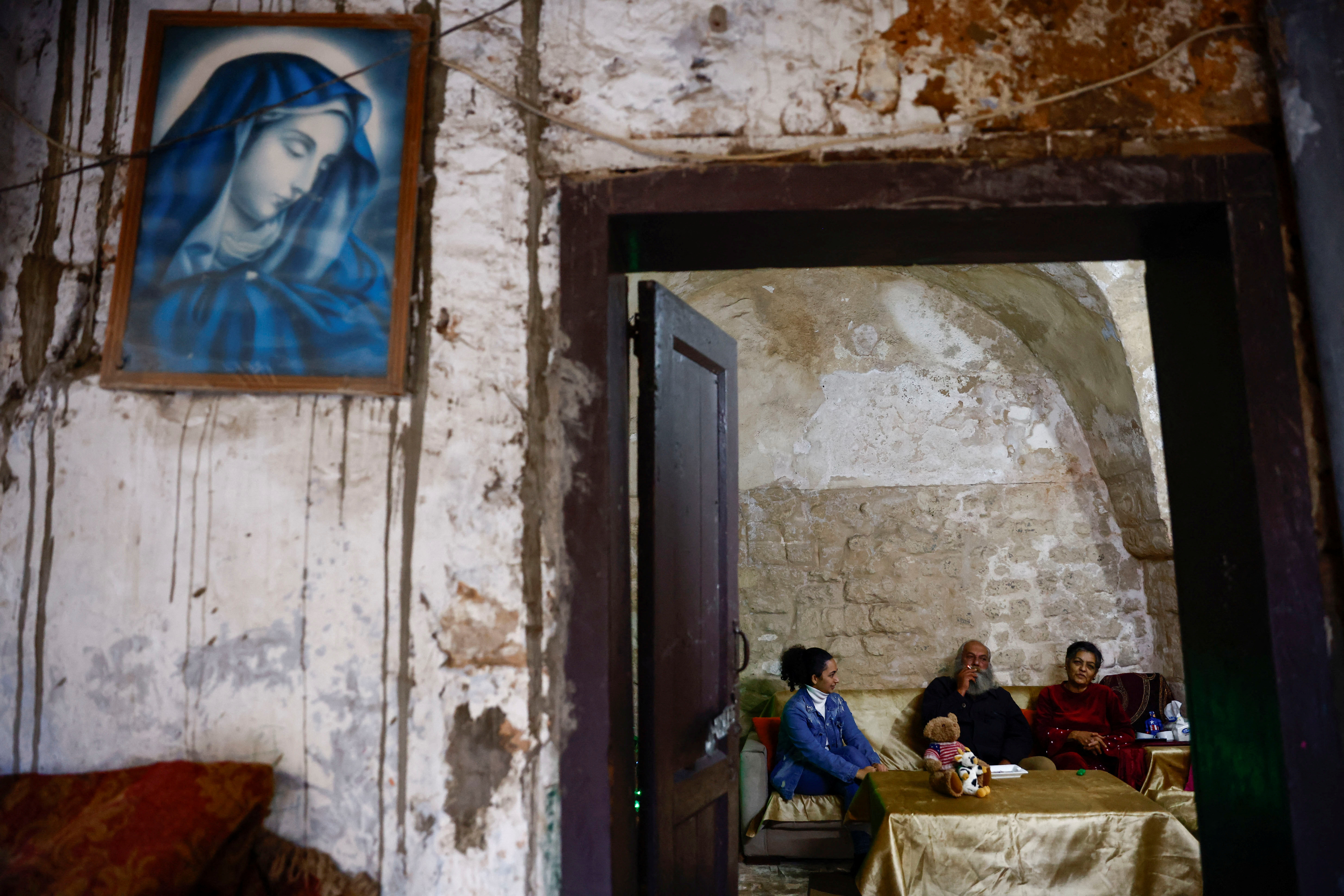 Thouraya Alameh sits on the sofa with her parents in their house in the southern Lebanese port city of Tyre