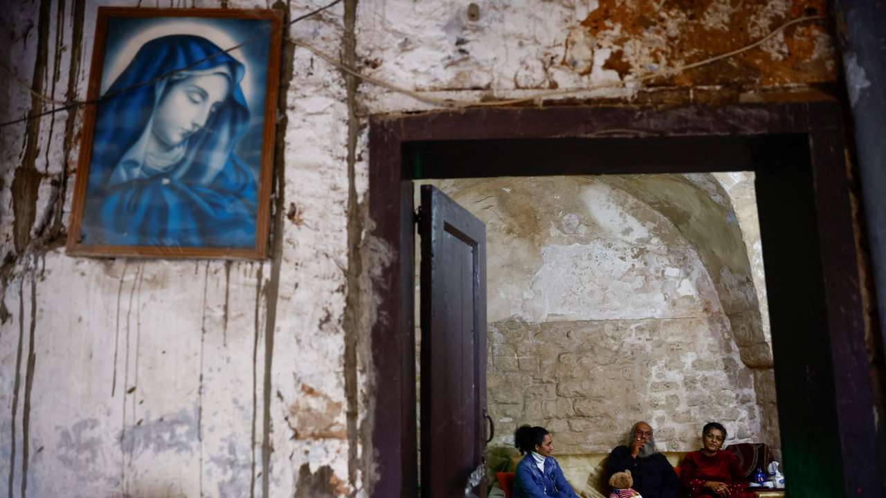 Thouraya Alameh sits on the sofa with her parents in their house in the southern Lebanese port city of Tyre