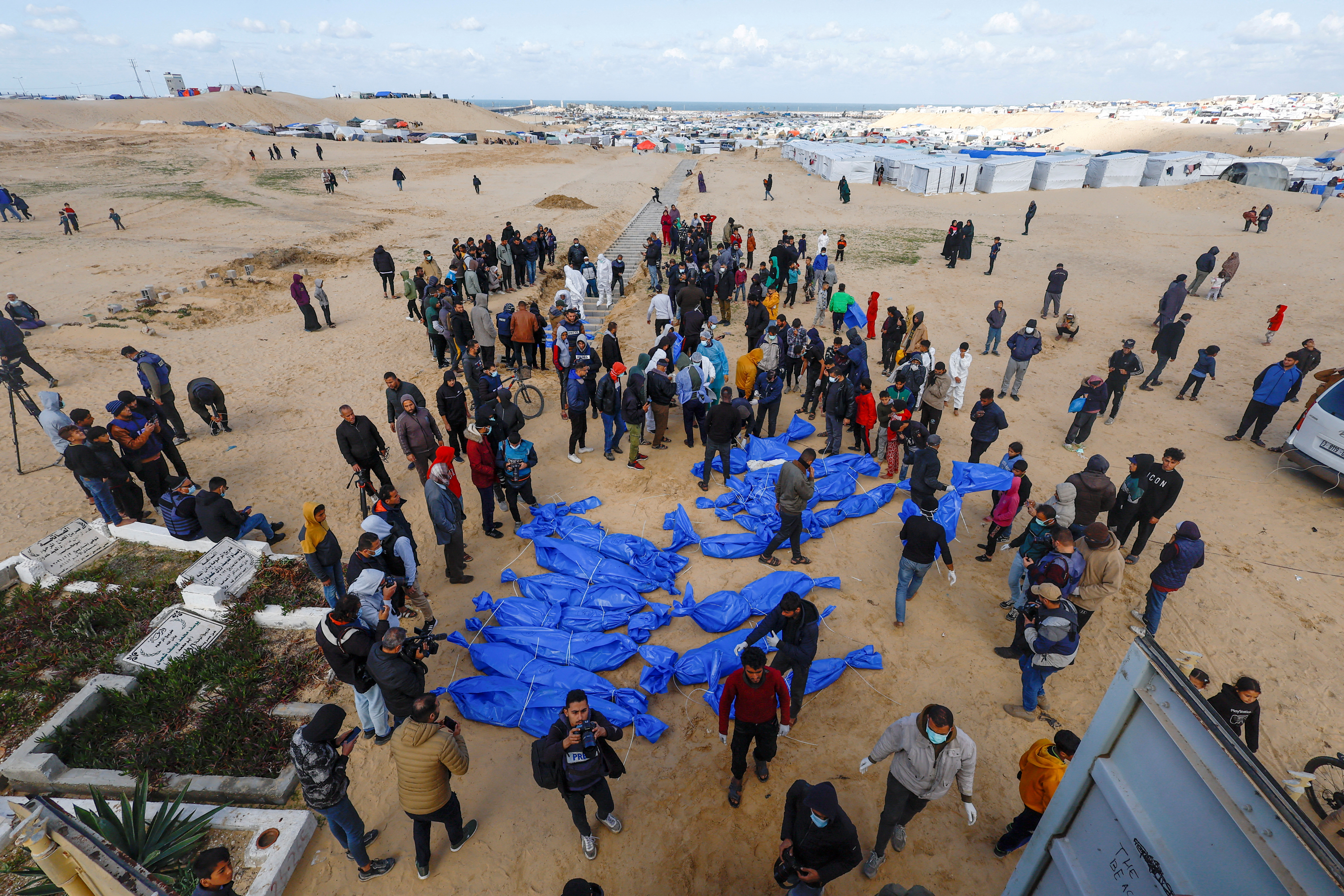 People bury Palestinians, including those who were killed in Israeli strikes and fire, after their bodies were released by Israel, in Rafah