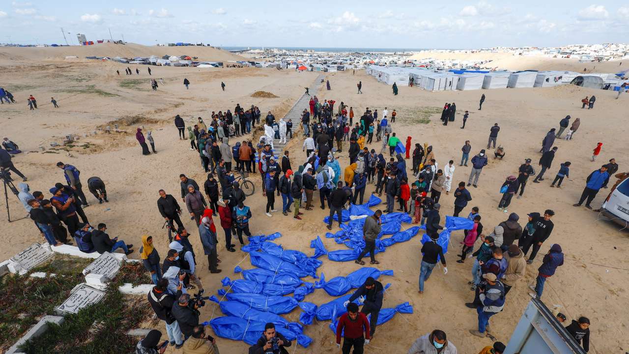 People bury Palestinians, including those who were killed in Israeli strikes and fire, after their bodies were released by Israel, in Rafah