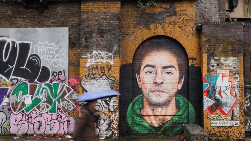 A pedestrian walks past a mural of Luigi Mangione, the suspect in the killing of UnitedHealth Group chief executive Brian Thompson, in East London