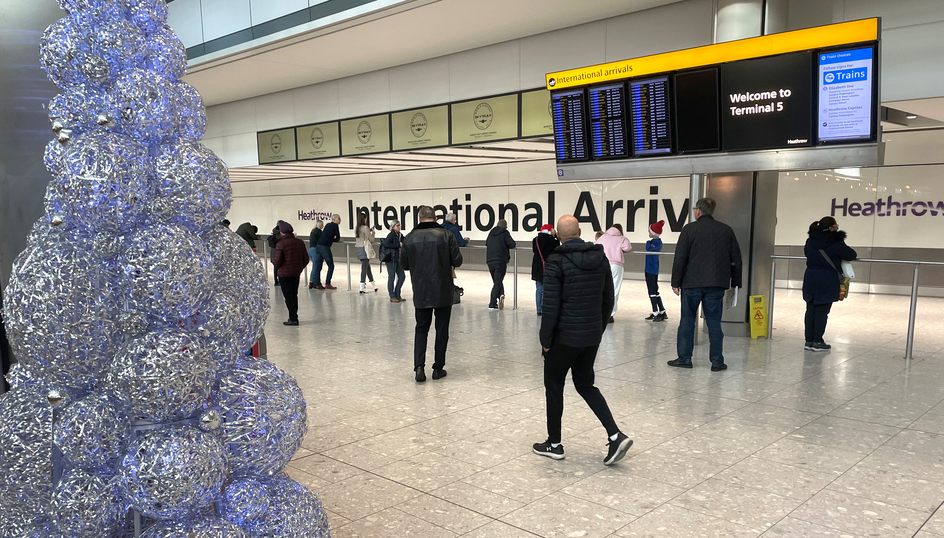 People wait in the arrivals hall at terminal 5 of Heathrow Airport, near London
