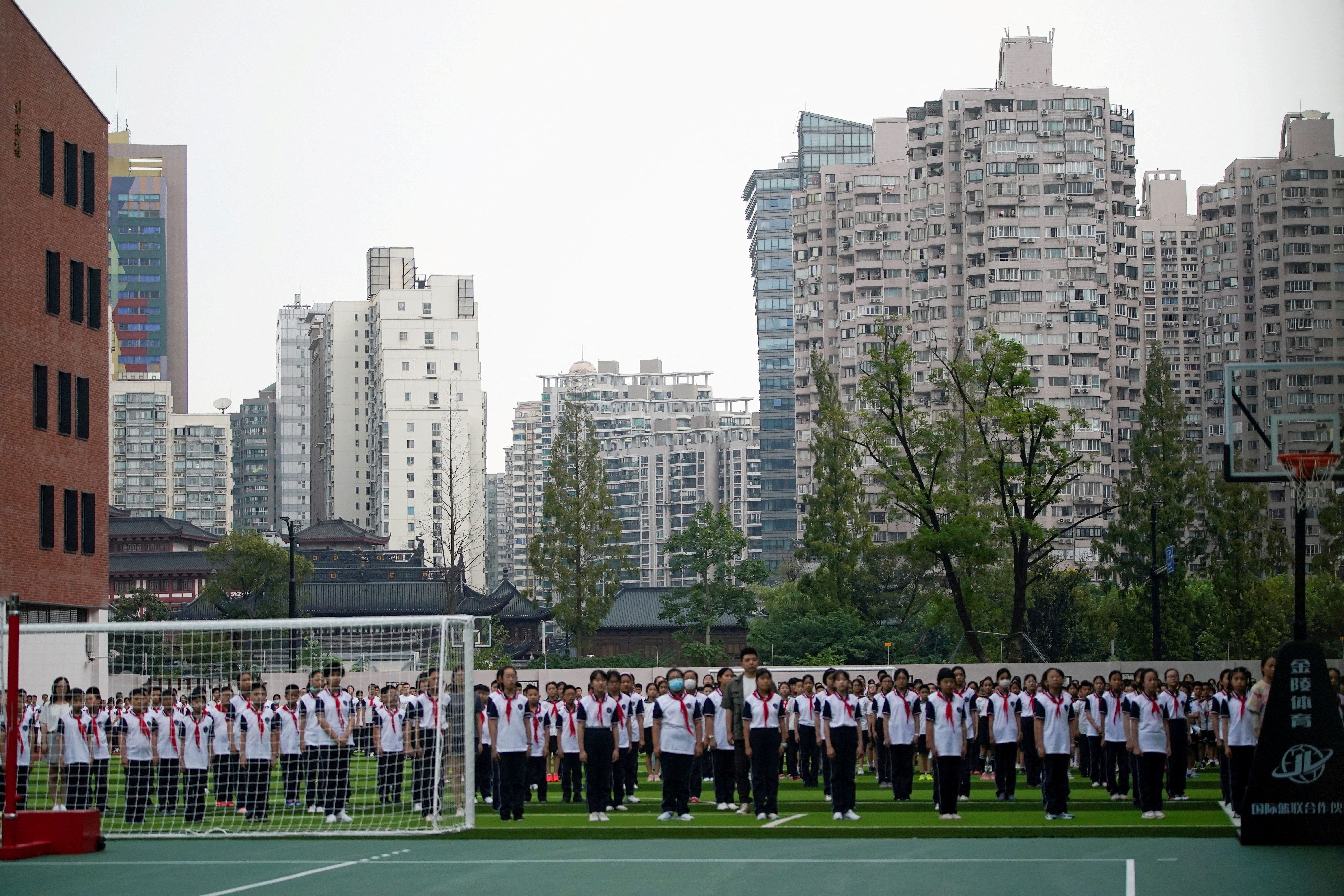 FILE PHOTO: Students stand at a school on the first day of new academic year in Shanghai