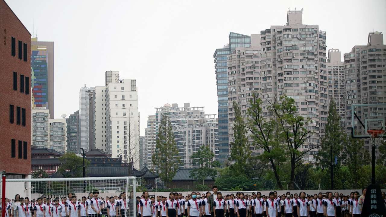 FILE PHOTO: Students stand at a school on the first day of new academic year in Shanghai