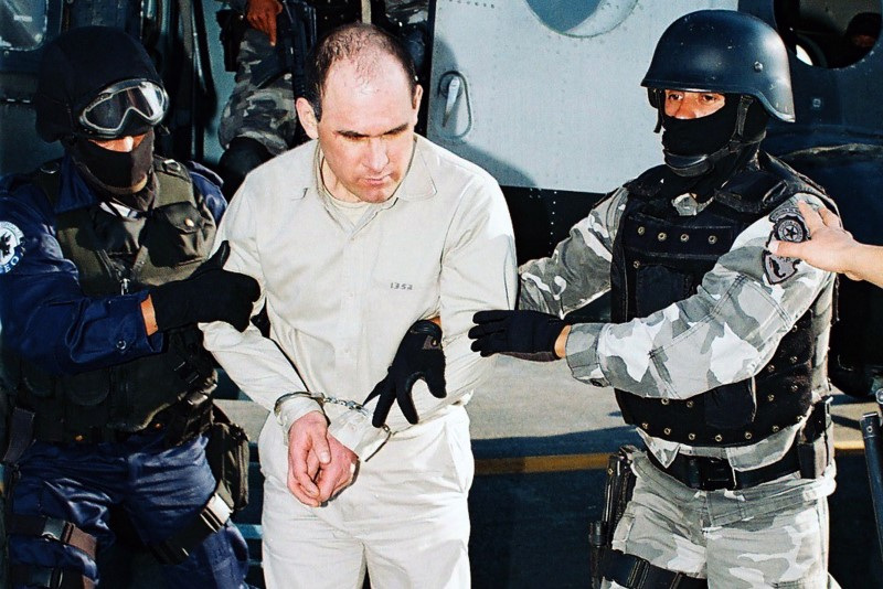 Handout photo shows suspected Gulf cartel boss Osiel Cardenas (C) being escorted by members of Mexico's Federal Agency of Investigations