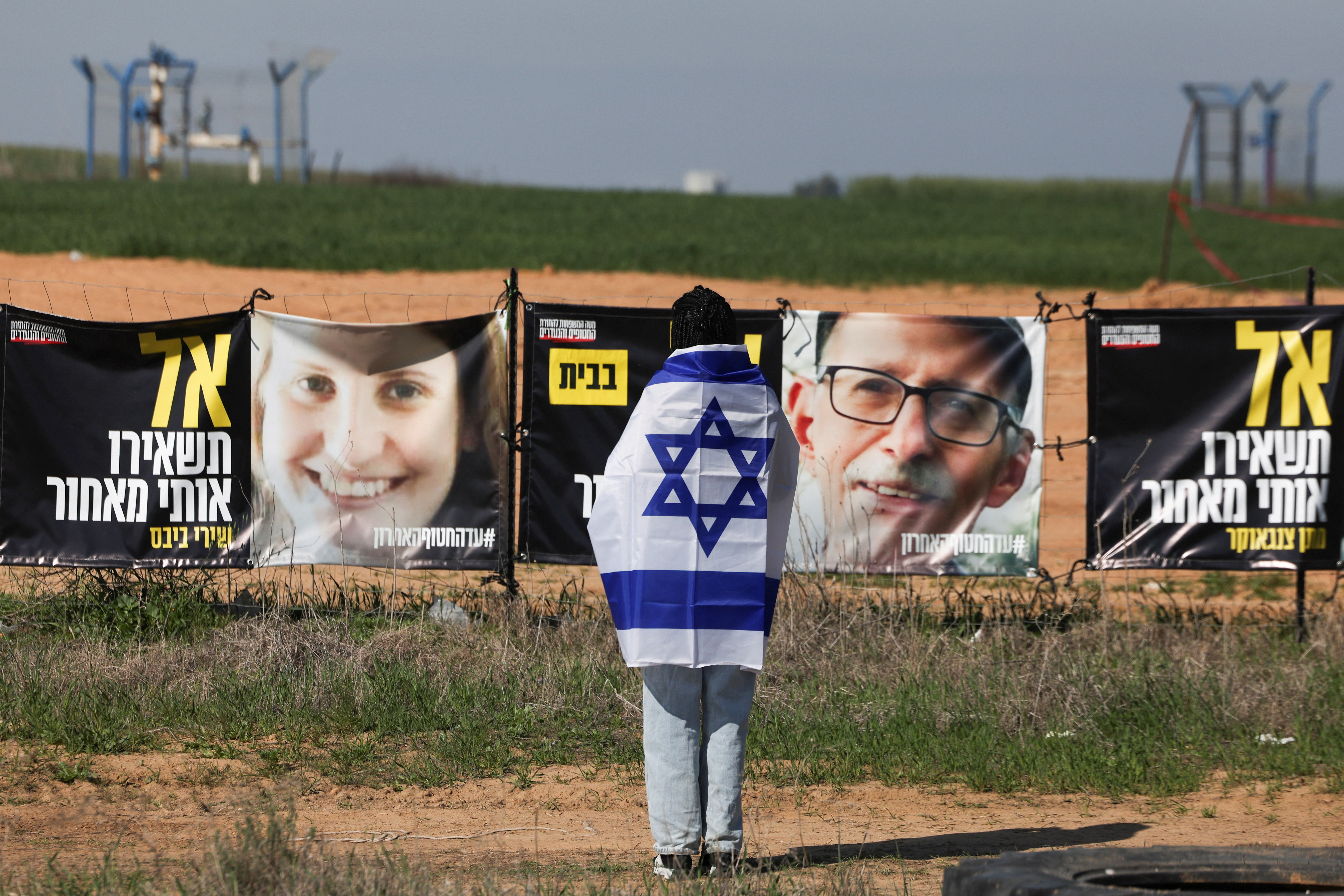 Israelis gather to bid farewell to Shiri, Ariel and Kfir Bibas, at a junction near Nir Oz