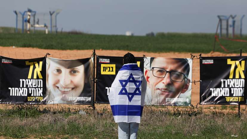 Israelis gather to bid farewell to Shiri, Ariel and Kfir Bibas, at a junction near Nir Oz
