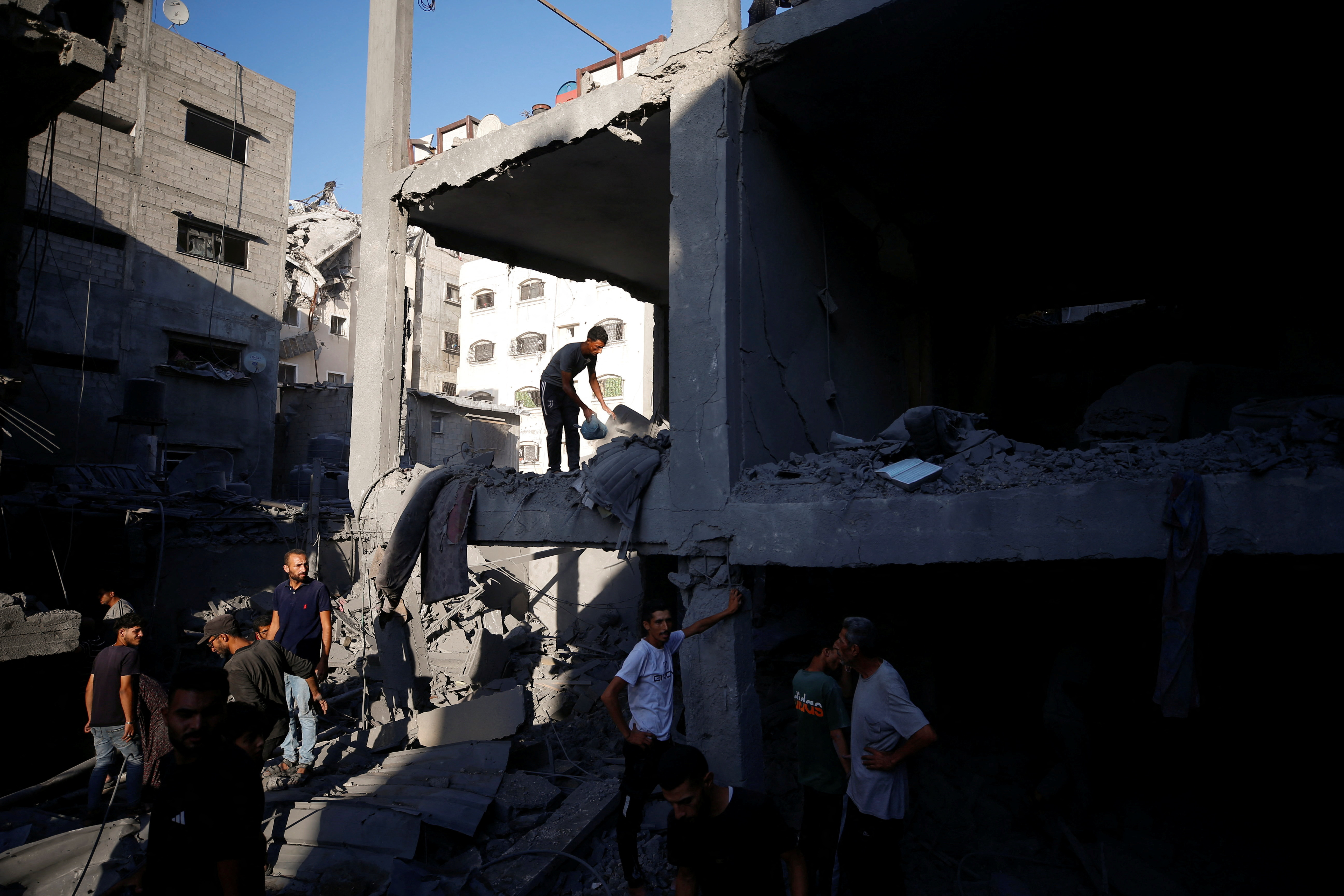 Palestinians inspect the site of an Israeli air strike on a house in Gaza City