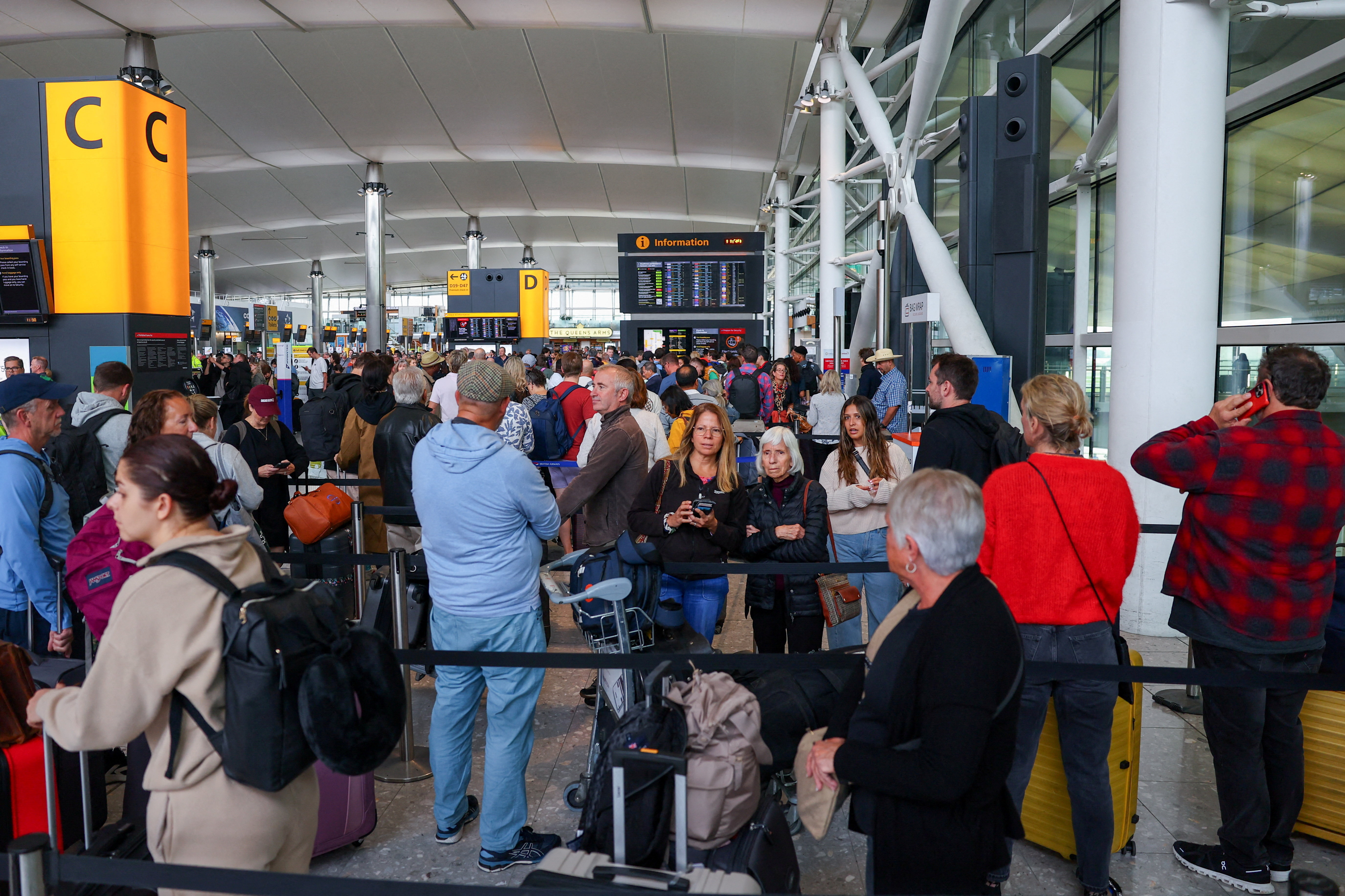 Travellers at Heathrow Airport amid cyberattack disruptions, in Greater London