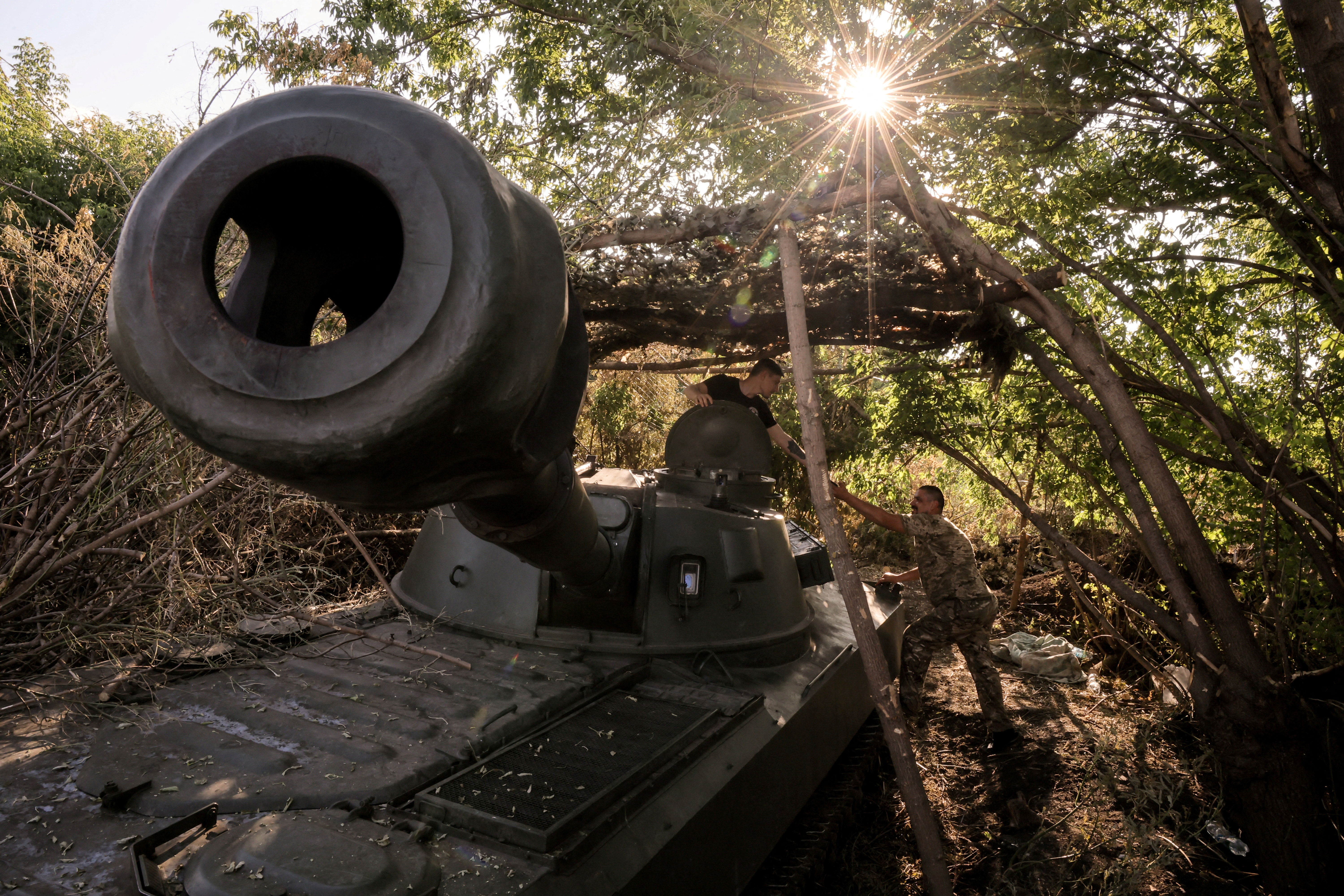 FILE PHOTO: Servicemen prepare a howitzer to fire towards Russian troops at a frontline near the town of Chasiv Yar